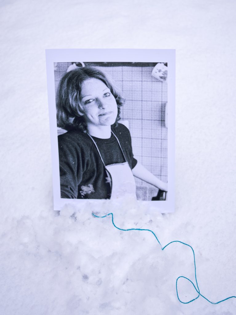 Portrait of Fiona positioned in the snow with a trail of cyan string leading to foreground